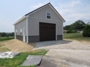 Custom two tone with light gray and dark gray metal siding, white trim, and a dark brown garage door with windows.