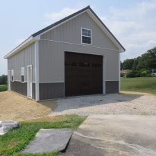 Custom two tone with light gray and dark gray metal siding, white trim, and a dark brown garage door with windows.